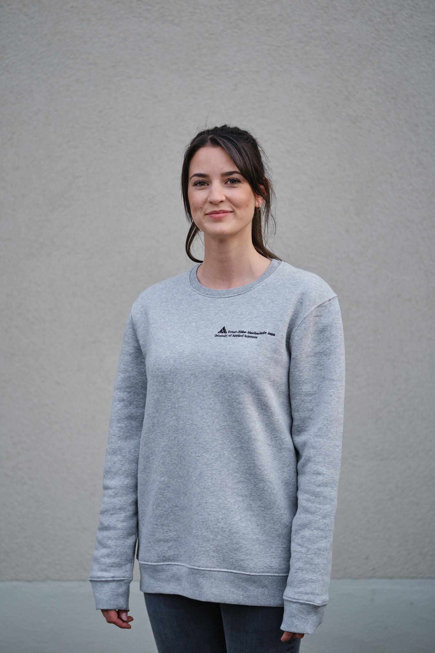 Model trägt ein graues Sweatshirt mit Logo der Ernst-Abbe-Hochschule